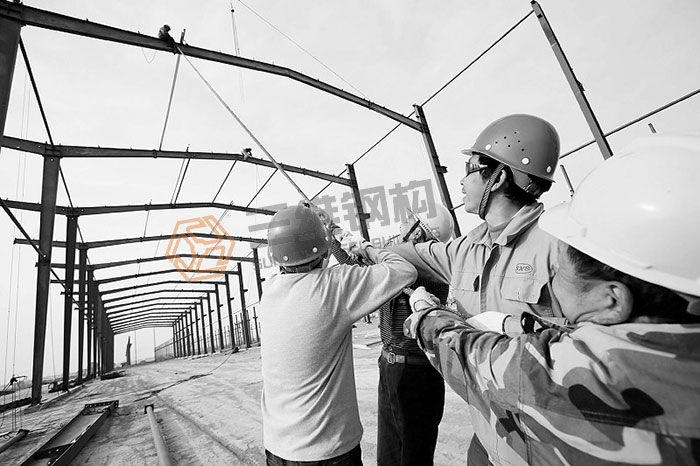 山东三维钢结构公司工人对轻钢结构厂房进行安装